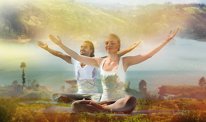 Image showing smiling couple making yoga exercises outdoors