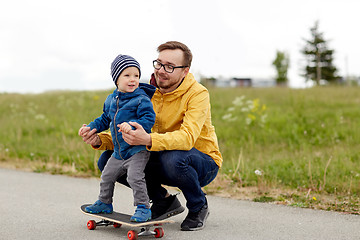 Image showing happy father and little son on skateboard