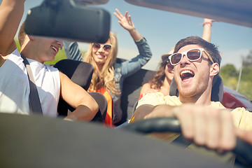 Image showing happy friends driving in cabriolet car