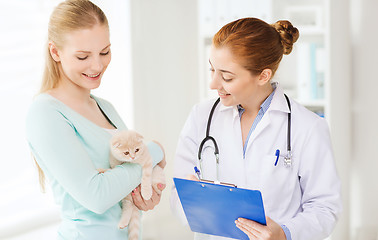 Image showing happy woman with cat and doctor at vet clinic