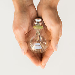 Image showing close up of hands holding edison lamp or lightbulb