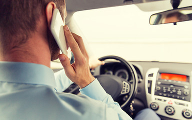 Image showing close up of man with smartphone driving car