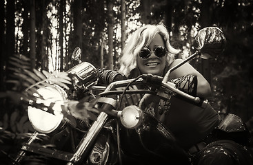 Image showing Mature woman biker on a motorcycle in sepia