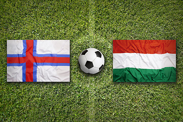 Image showing Faeroe Islands vs. Hungary flags on soccer field