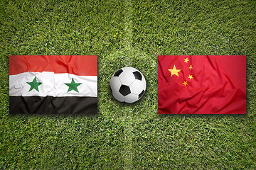 Image showing Syria vs. China flags on soccer field