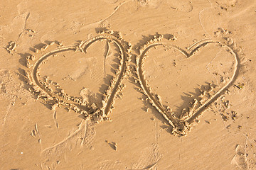 Image showing Two hearts drawn in the sand on the sea beach