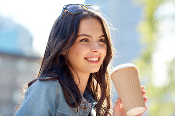 Image showing happy young woman drinking coffee on city street