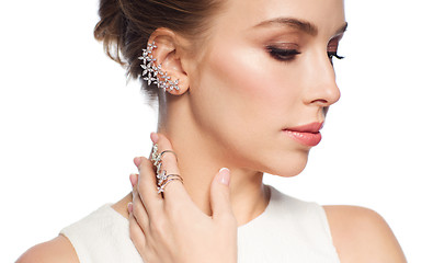 Image showing smiling woman in white dress with diamond jewelry