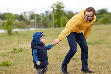 Image showing happy father and little son walking outdoors