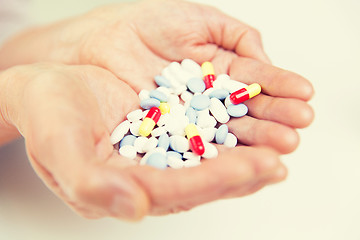 Image showing close up of senior woman hands with pills