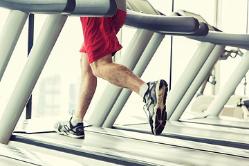 Image showing close up of male legs running on treadmill in gym