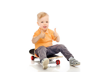 Image showing happy little boy on skateboard showing thumbs up