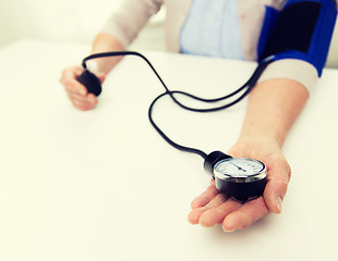 Image showing old woman with tonometer checking blood pressure