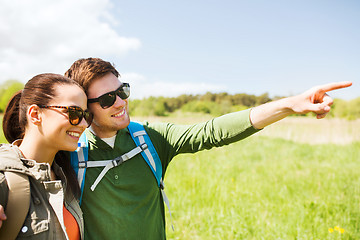 Image showing happy couple with backpacks hiking outdoors