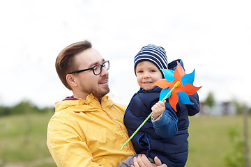 Image showing happy father and son with pinwheel toy outdoors