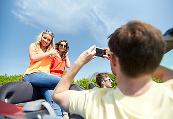 Image showing friends driving in car and photographing