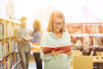 Image showing happy student girl or woman with book in library