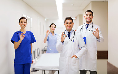 Image showing happy doctors with gurney showing ok at hospital