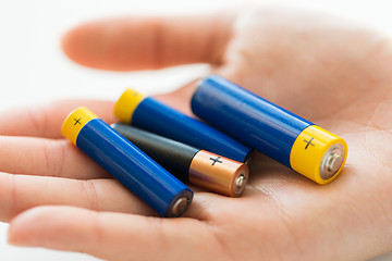 Image showing close up of hands holding alkaline batteries heap