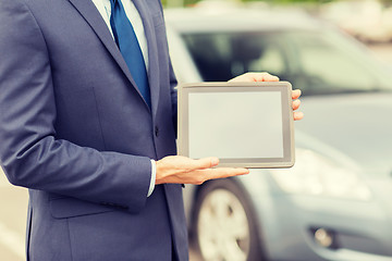 Image showing close up of young man with tablet pc and car