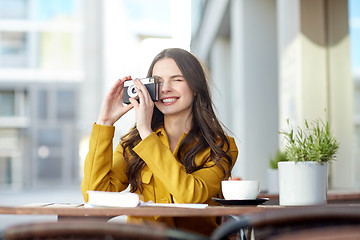 Image showing happy tourist woman with camera at city cafe