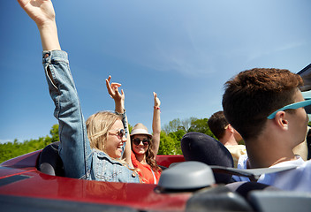 Image showing happy friends driving in cabriolet car at country