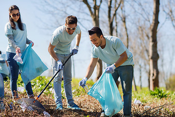 Image showing volunteers with garbage bags cleaning park area