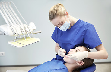 Image showing female dentist checking patient girl teeth