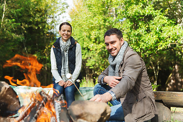 Image showing happy couple roasting marshmallow over camp fire