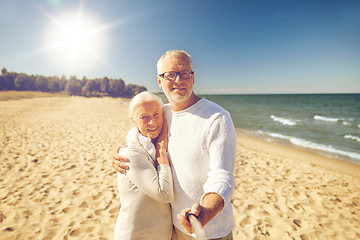 Image showing seniors taking picture with selfie stick on beach