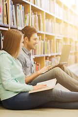 Image showing happy students with laptop in library