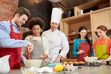 Image showing happy friends and chef cook baking in kitchen