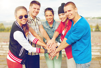 Image showing teenagers hands on top of each other outdoors