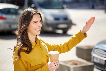 Image showing happy young woman drinking coffee on city street