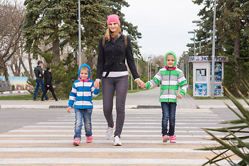 Image showing Anapa, Russia - March 9, 2016: a young mother with two daughters cross the road at a pedestrian crossing