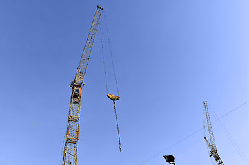 Image showing Crane and building construction site against blue sky