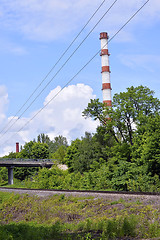 Image showing Industrial boiler pipe on a background of green trees