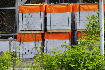 Image showing White clay bricks, stacked on pallets in an open warehouse