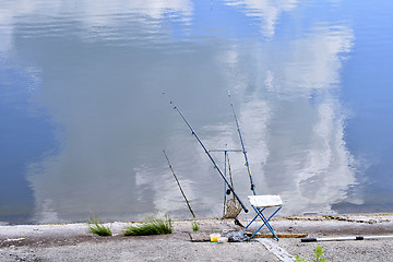 Image showing Chair with fishing poles and fishing equipment at the lake