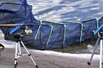 Image showing Chair with fishing poles and fishing equipment at the lake