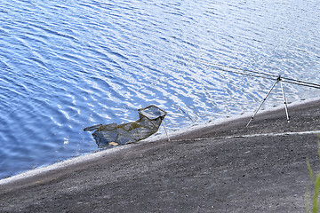 Image showing Chair with fishing poles and fishing equipment at the lake