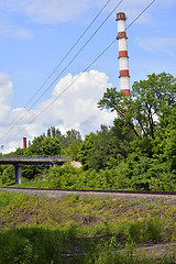 Image showing Industrial boiler pipe on a background of green trees