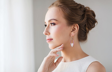 Image showing smiling woman in white dress with pearl jewelry