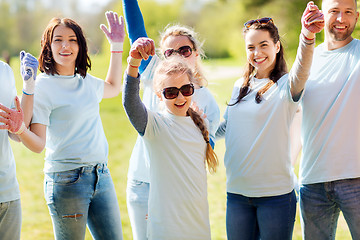 Image showing group of volunteers celebrating success in park