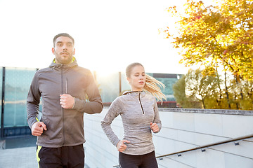 Image showing happy couple running upstairs on city stairs