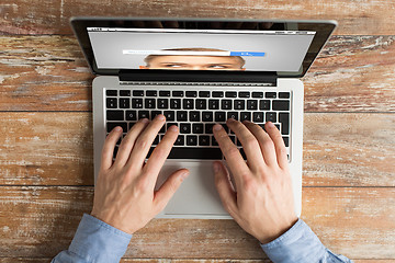 Image showing close up of male hands with laptop typing