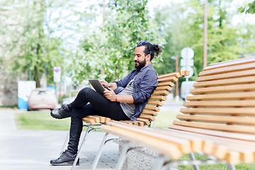 Image showing man with tablet pc sitting on city street bench