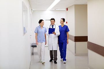 Image showing group of smiling medics at hospital with clipboard