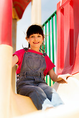 Image showing happy little girl on slide at children playground