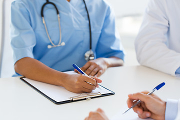 Image showing group of doctor with clipboard writing at hospital